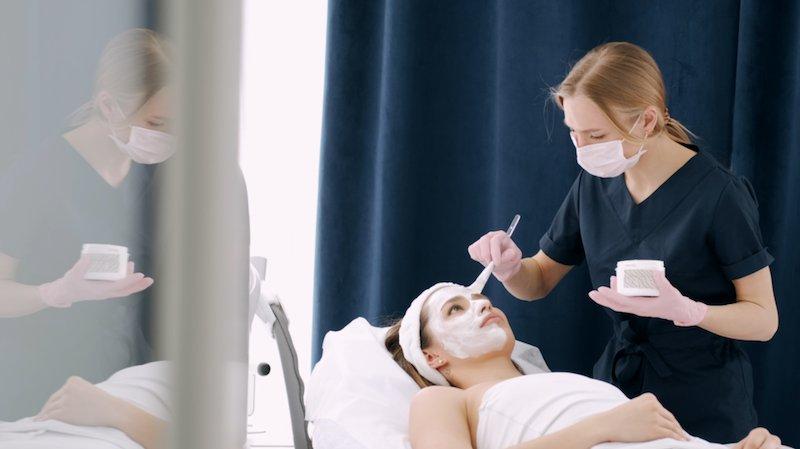 An esthetician applying a facial treatment