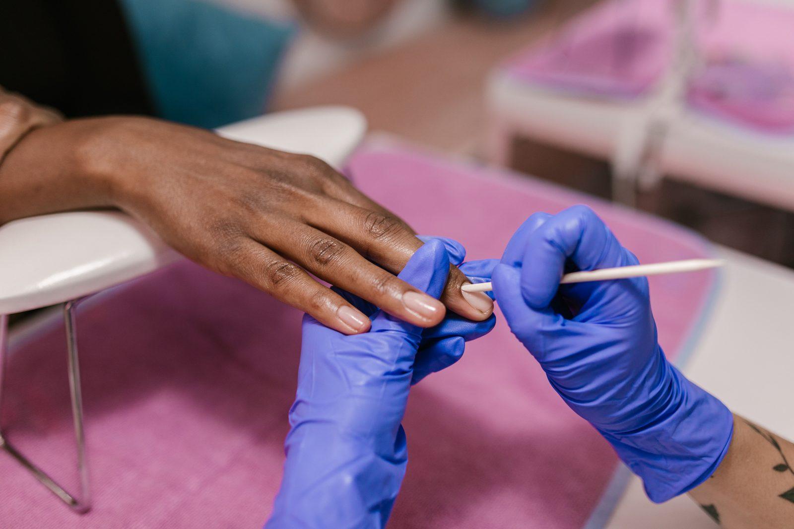 A nail technician performing a manicure